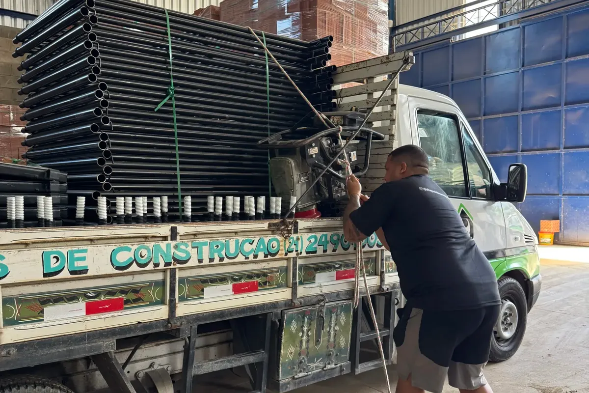 Equipe do Aluguel do Construtor amarrando a carga de andaimes no caminhão antes da entrega